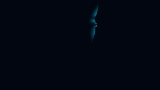 Mysterious Human Face Emerging from Darkness with Subtle Light Revealing Emotion and Intrigue in a Creative Artistic Photograph