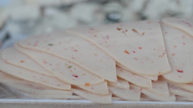 Close up video of cooked turkey breast slices arranged in stack for delicious meal.