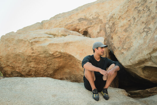Young climber resting on sandstone boulder in Joshua Tree