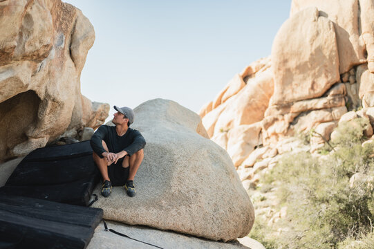 Climber assessing route while resting in Joshua Tree landscape