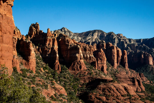Dramatic red rock cliffs and layered canyon walls under blue sky