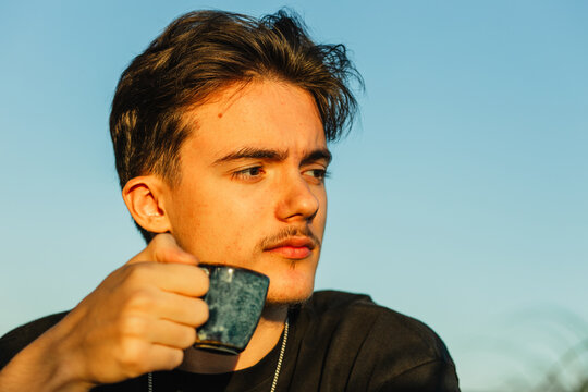 Young person with warm drink during outdoor contemplation