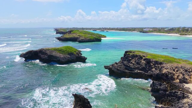 Aerial view of rocky limestone islets surrounded by turquoise ocean water and breaking waves along the coast of Watamu Beach, Kenya.