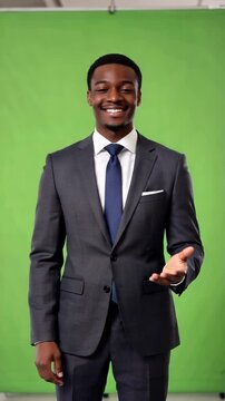 Black young adult businessman on green screen beckons come here with confident inviting energy for recruitment onboarding sales or presenter led business scenesblack man