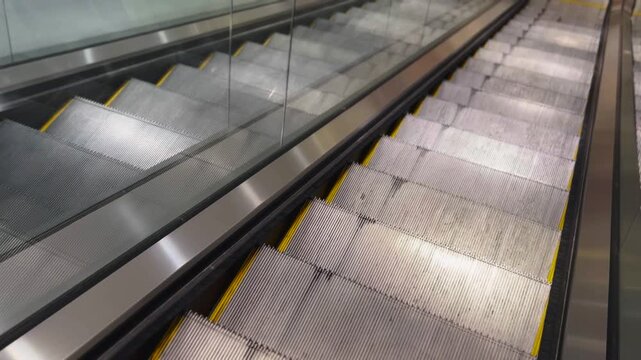 Moving escalator close-up with repeating steps and clean design, transportation and architecture concept, 4K