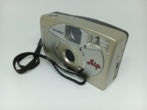 Tegal, INDONESIA, 17 March 2026 - Silver disposable camera with black strap, ideal for vintage, retro, photography, and travel related designs, backgrounds, and concepts for creative projects.