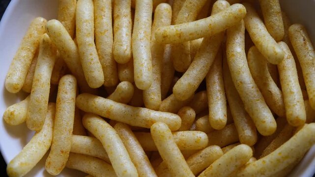 Close-up of Spiced Corn Puff Sticks in White Bowl