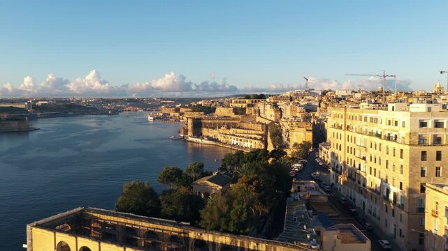Flyover Historic Walled City Of Valletta, Malta At Sunrise Along The Mediterranean Sea. Aerial Drone Shot