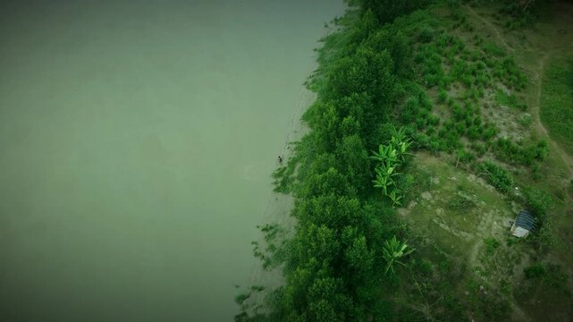 Aerial Top-Down View of a Fisherman Casting a Net in a Murky River In Bangladesh 4k