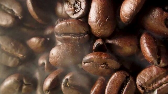 Close up of steam rising from roasted brown coffee beans