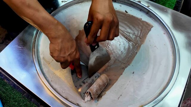 Street Vendor Rolling Chocolate Ice Cream on Cold Plate, Thai Street Food Dessert Process, 4K