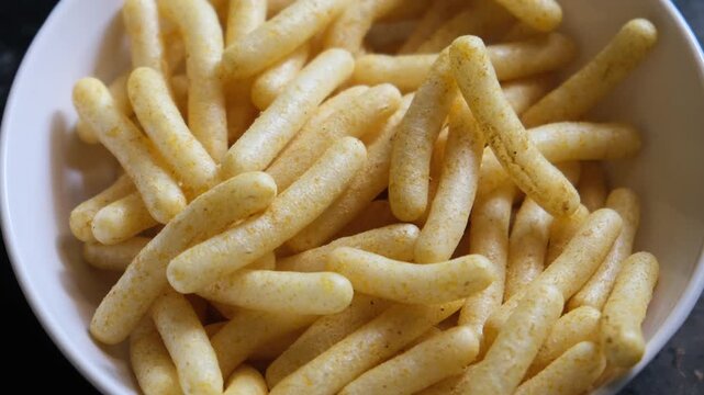 Crunchy Corn Puff Sticks in a White Bowl