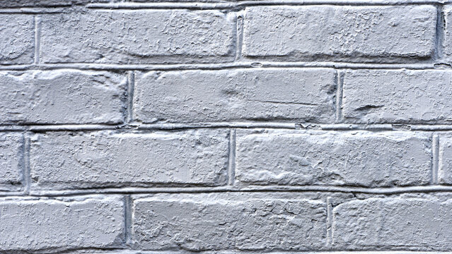 background, brick wall in fresh whitewash. brick wall facade texture. old grey bricks in an exterior uneven wall of a house with whitewashed worn plaster. masonry, construction, repair, restoration
