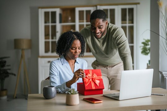 Woman showing disappointment receiving bad gift from man