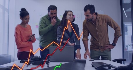 Collaborating team in blazer, sweater reviewing documents, pointing at laptop and phone in office © vectorfusionart