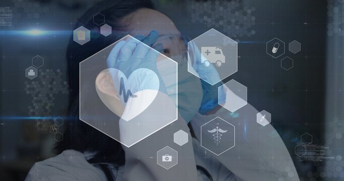 Adjusting Korean clinician wearing protective gear and stethoscope in hospital with medical HUD