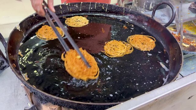 jalebi frying in hot oil in large kadhai indian street sweet making process close up