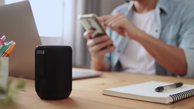 Smart Speaker Virtual Assistant or Artificial Intelligence Concept by Man Connecting Smart Phone with Smart Speaker