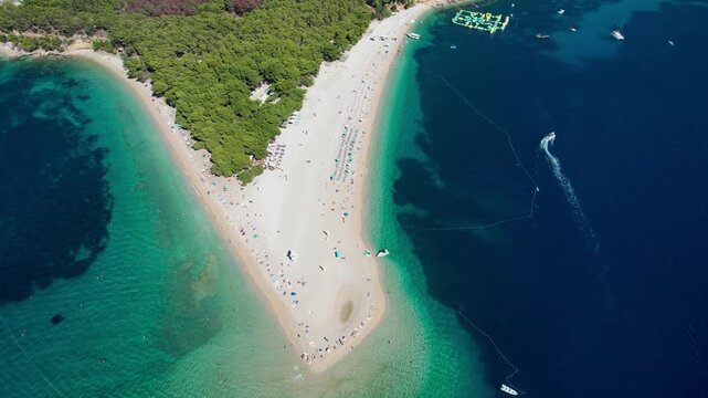 Aerial view of the iconic Zlatni Rat beach surrounded by turquoise waters and a lush green forest, Bol, Dalmatian Coast, Croatia.