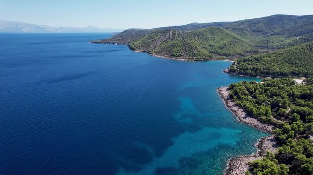 Aerial view of the stunning turquoise waters meeting the lush green coastline, a beautiful contrast of colors, Jelsa, Split-Dalmatia County, Croatia.