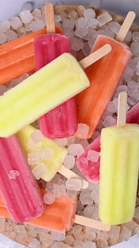 Colorful ice pops rotating on surface close up loop. Top view