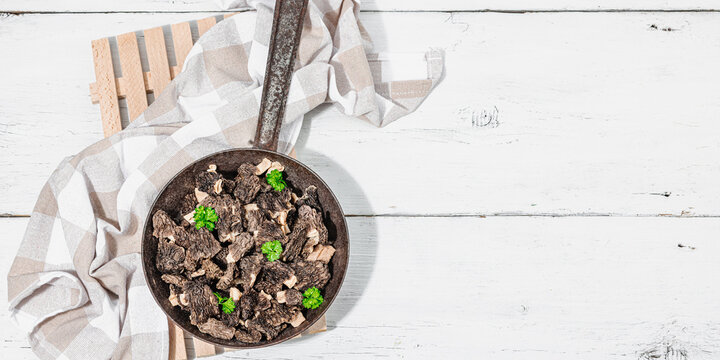 Raw black morel mushrooms with fresh parsley. Vegan ingredient for cooking healthy food