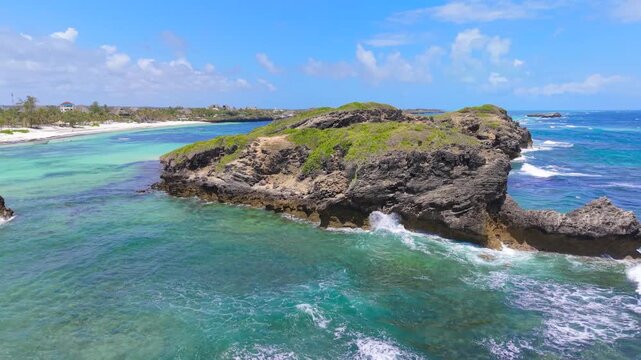 Aerial view of volcanic rock formations and turquoise ocean water along the white sand coastline of Watamu Beach, Kenya.