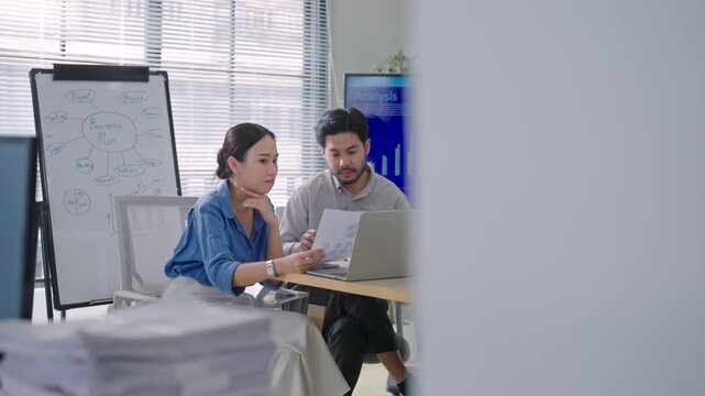 Professional Asian business people brainstorming and presenting global sales data, marketing strategy, and logistics planning in a modern office.