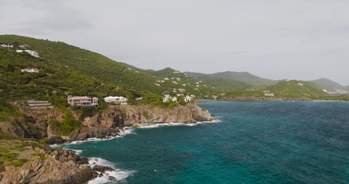 Aerial view of two ruins on a cliff overlooking the turquoise water, complemented by lush green hills, St. John, St. John, US Virgin Islands.