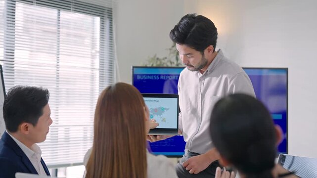 Close up Professional Asian business people brainstorming and presenting global sales data, marketing strategy, and logistics planning in a modern office.