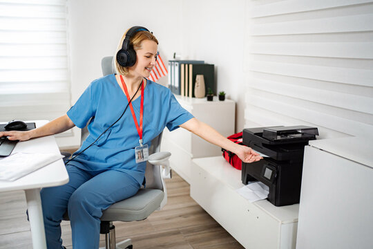 Female nurse working in office multitasking and using printer