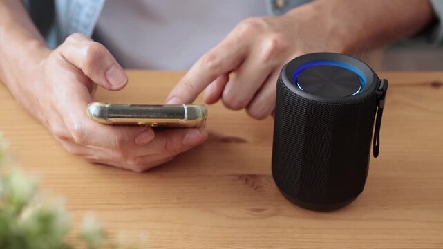 Front View Smart Speaker Virtual Assistant or Artificial Intelligence Concept by Man Connecting Mobile Phone with Smart Speaker