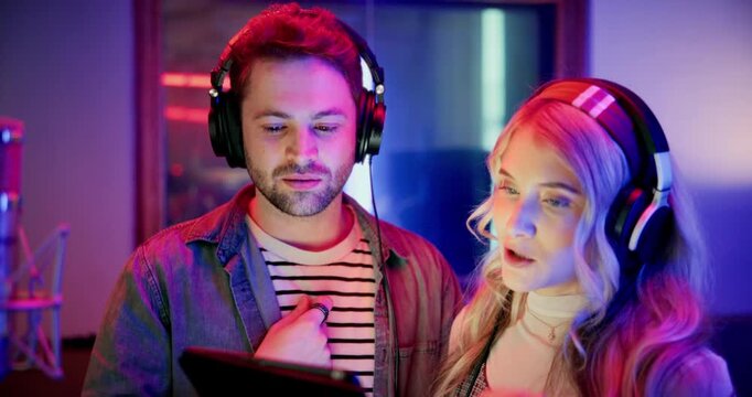 Happy, man and woman with tablet in recording studio, artist or creative with song lyrics on website. Entertainment, singer and people with headphones for music, post production and team with tech