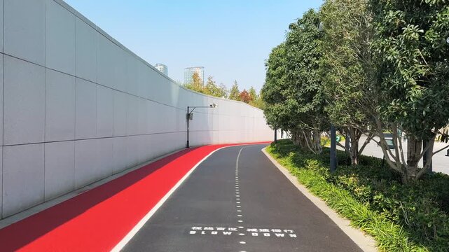 Pov motion on Riverside Cycling Path Along White Wall in the city