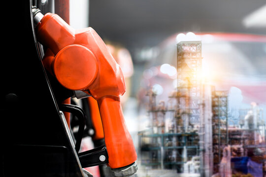 Fuel Nozzle and Refinery Plant, A close-up of a red fuel pump nozzle overlaid with a double exposure of a lit industrial refinery at night for gas and oil themes.