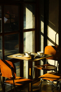 Cozy cafe table with coffee cups and warm sunlight through a window