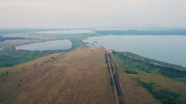 Aerial view flying over a lakeshore isthmus