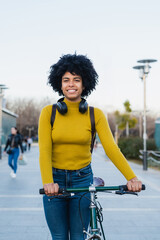 Obraz premium Young woman smiling holding urban city bike