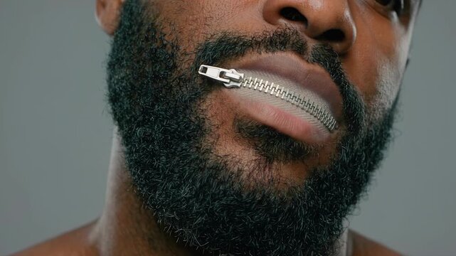 African American man with a metal zipper on his mouth unzipping lips. Censorship and freedom of speech concept. Person keeping a secret macro close up