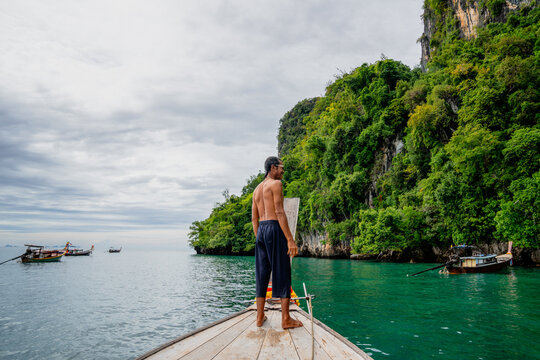 Man travelling on a longtail boat in thailand