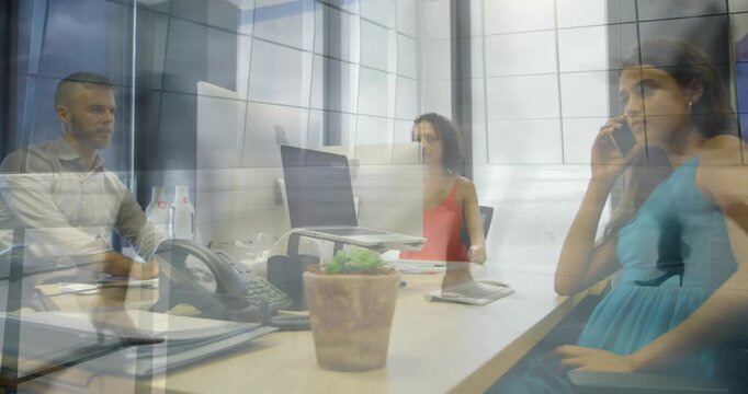 Team sitting business meeting reading notes and calling blurred figure crossing frame ghosting view