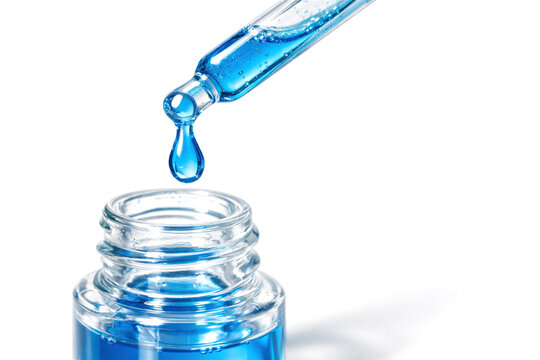 Dropper with blue peptide serum dripping into glass bottle. Cosmetic skincare product for facial treatment. Anti aging beauty liquid for deep hydration. Laboratory science research and medicine.