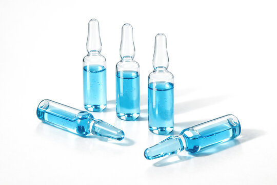 medical ampoules with blue peptide copper serum on white background. Glass vials containing medication for injection. Pharmaceutical drug, healthcare treatment, chemistry research and clinical science