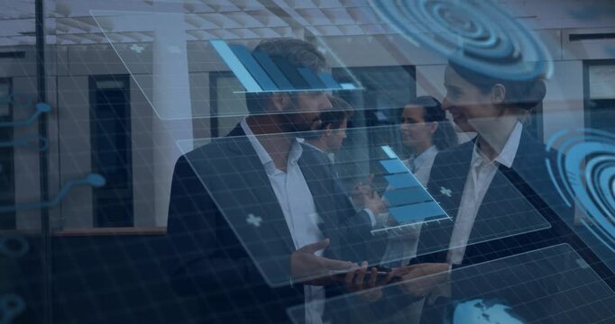 Vertical video: Pointing duo in suits showing data in atrium as overlays rise, holding tablet