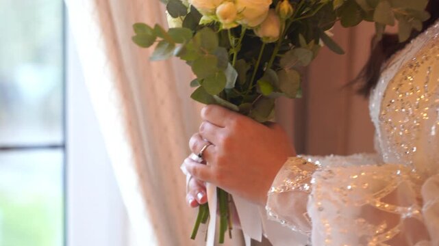 Wedding bouquet with white roses and green leaves. Bride in dress holds bouquet. Advert for wedding agency