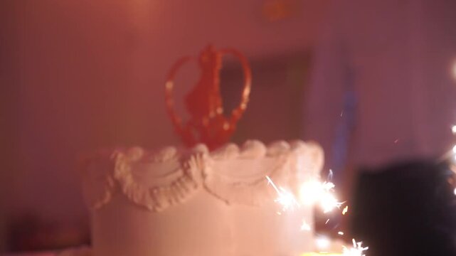 Elegant wedding cake with rings and white flowers, held by newlyweds in celebration