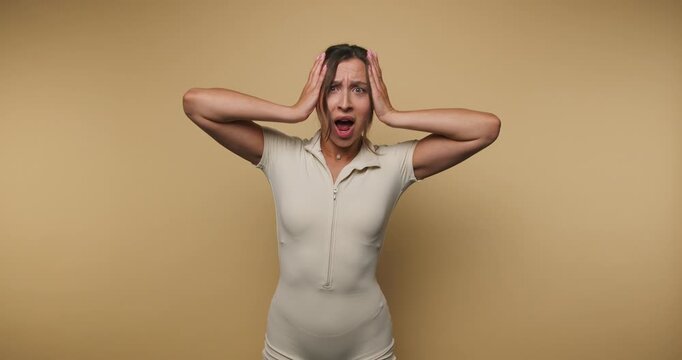 Woman expresses strong emotions with hand gestures in a simple setting