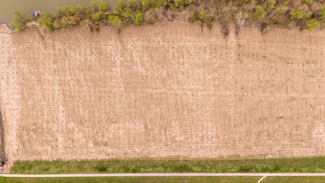 Aerial view of the field with the tracks and vegetation along the edge creating a contrast of textures, Sremska Mitrovica, Vojvodina, Serbia.