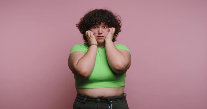 Exploring emotions through body language in a studio with pink background and a person showing various expressions