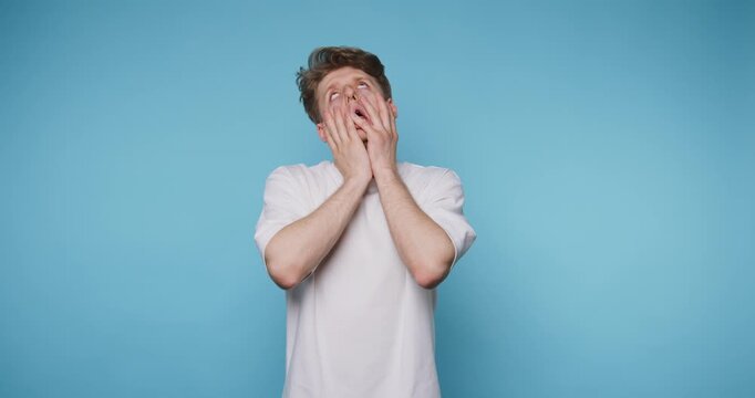 Man shows different facial expressions against a blue background while engaging in playful activities in a light setting